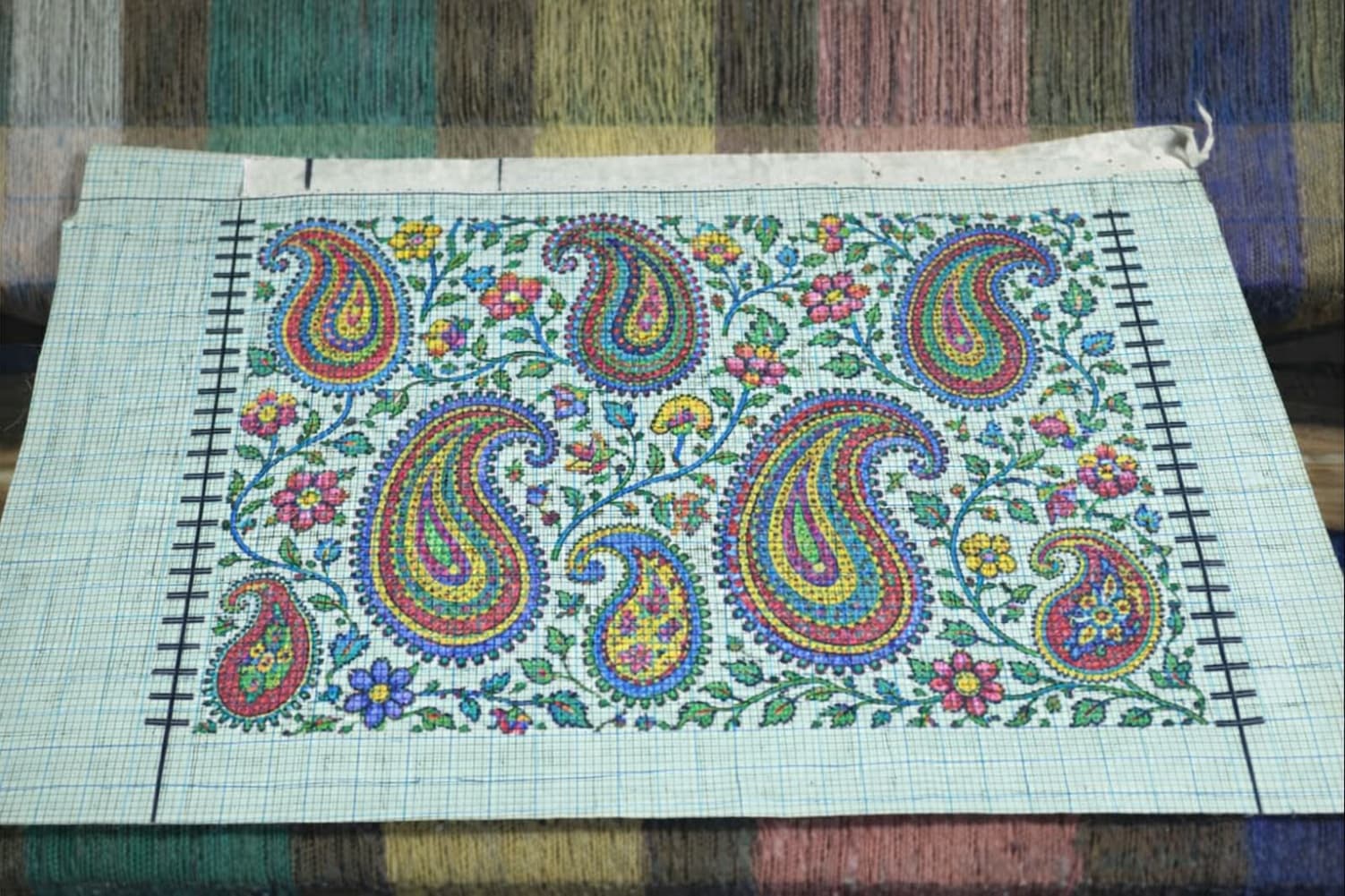 Naqash designing Kani shawl pattern on graph paper